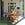 Wooden outdoor dining set on a porch with plants and decor.