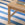 Wooden table with books on a blue and white striped rug