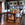 Dining room with wooden table and chairs, potted plants, and a fireplace.