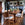 Dining room with wooden table and chairs, potted plants, and a fireplace.