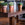 Three potted plants on a wooden hand carved dining table with a blurred background