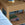 Woven wooden side table with books on a blurred background