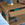 Woven wooden side table with books and decorative lamp