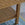 Close-up of a woven rattan table with shelf and a textured surface.