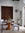 Dining room with wooden table and chairs, floral arrangement, and decorative elements.