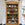 Wooden bookshelf with decorative items in a room with a table and chairs.
