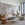 Living room with beige sofa, wicker chair, and decorative wall art