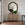 Decorative dresser with a large octagonal mirror above it in a room with wooden flooring.