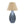 Table lamp with blue base with fern design and beige shade on a white background