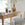 Wooden desk with a lamp, books, and a plant in a bright room.