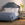 Bedroom with a blue upholstered bed and white bedding, featuring a side table with a vase.