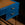 Blue desk with two drawers and wooden surface on a dark background