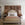 Neatly made bed in a bedroom with decorative wall art and side tables.