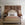 Neatly made bed in a bedroom with decorative wall art and side tables.